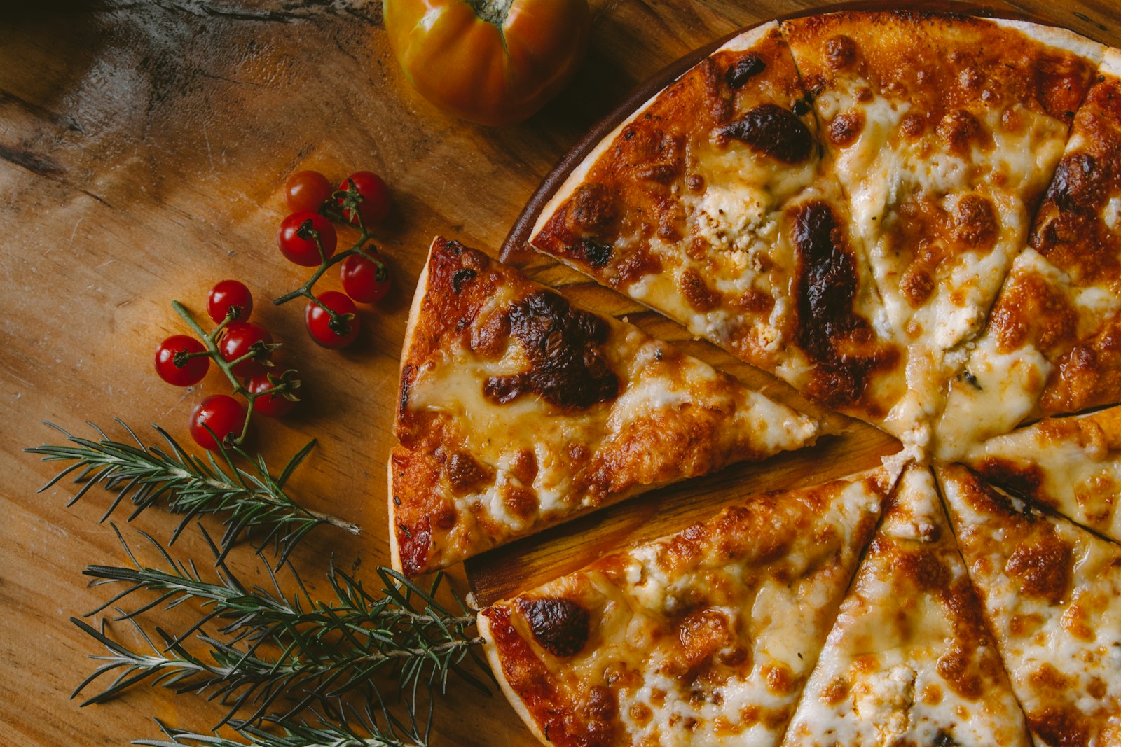 Verse pizza met gesmolten kaas op een houten plank