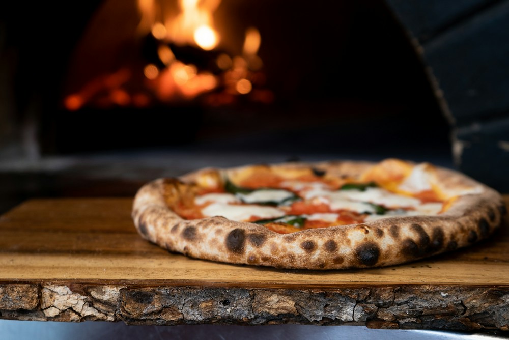Pizza met een goudbruine korst voor de steenoven